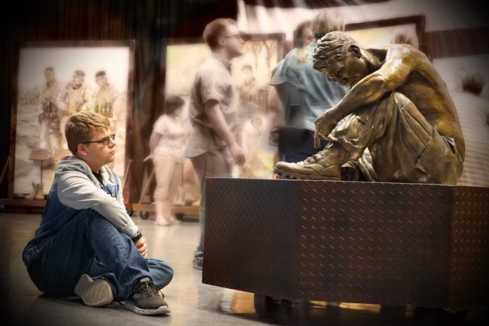 Young person looking at the Silent Battle statue