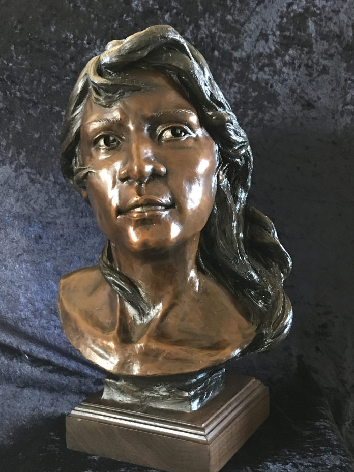 Bronze sculpture of a person's head and face