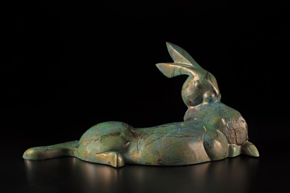 Bronze sculpture of a reclining rabbit