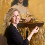 Artist Spotlight: Nanette Fluhr Female artist standing in front of a life-sized painting of a woman