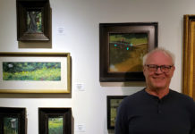 Artist Spotlight: Ray Hassard Male artist standing in front of his work in a gallery