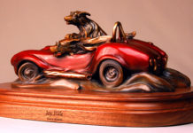 Featured Artwork: Gary Alsum Bronze sculpture of dogs driving in a red racing car