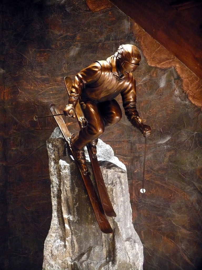 Bronze sculpture of a person skiing 