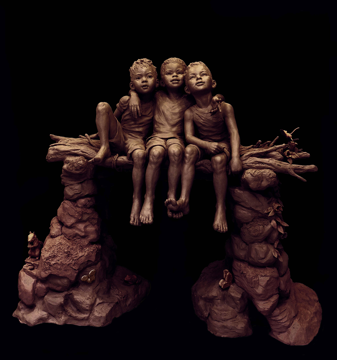 bronze statue of children sitting on log