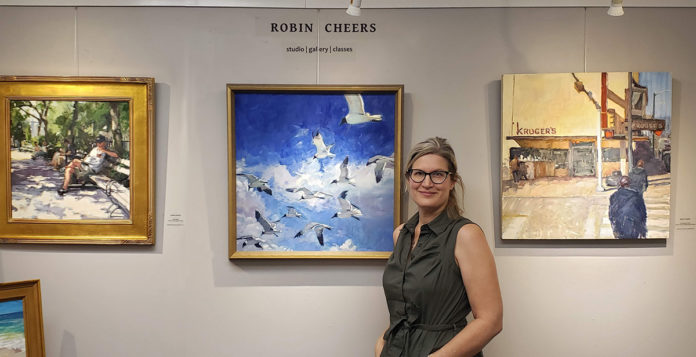 artist smiling with her painting hanging