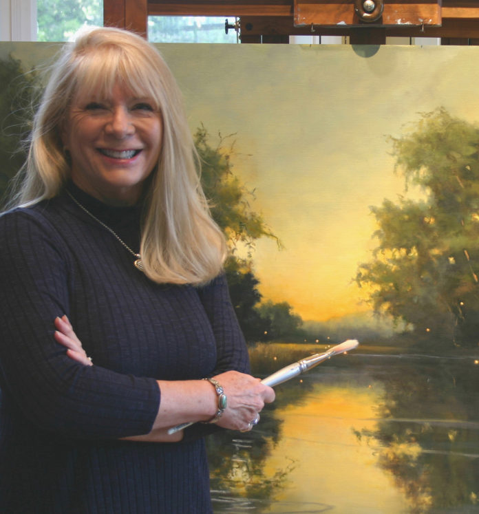 Artist posing with her artwork, holding a paint brush