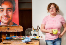Artist Spotlight: Nadine Robbins artist posing for a photo with the portrait of her son