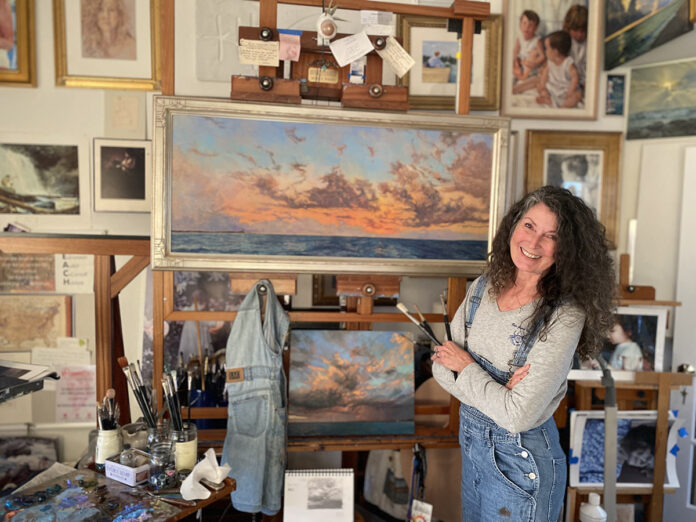 artist with her current paintings in her studio