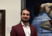 Artist Spotlight: Nik Anikis artist posing with his painting in Sotheby's exhibition