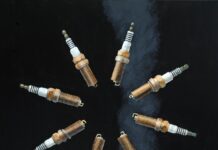 Artist Spotlight: Peter Swift oil painting of plus in a circle; black canvas with a line of smoke in background