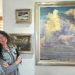 Artist Spotlight: Karen Ann Hitt Karen at her home studio, posing with her paintings