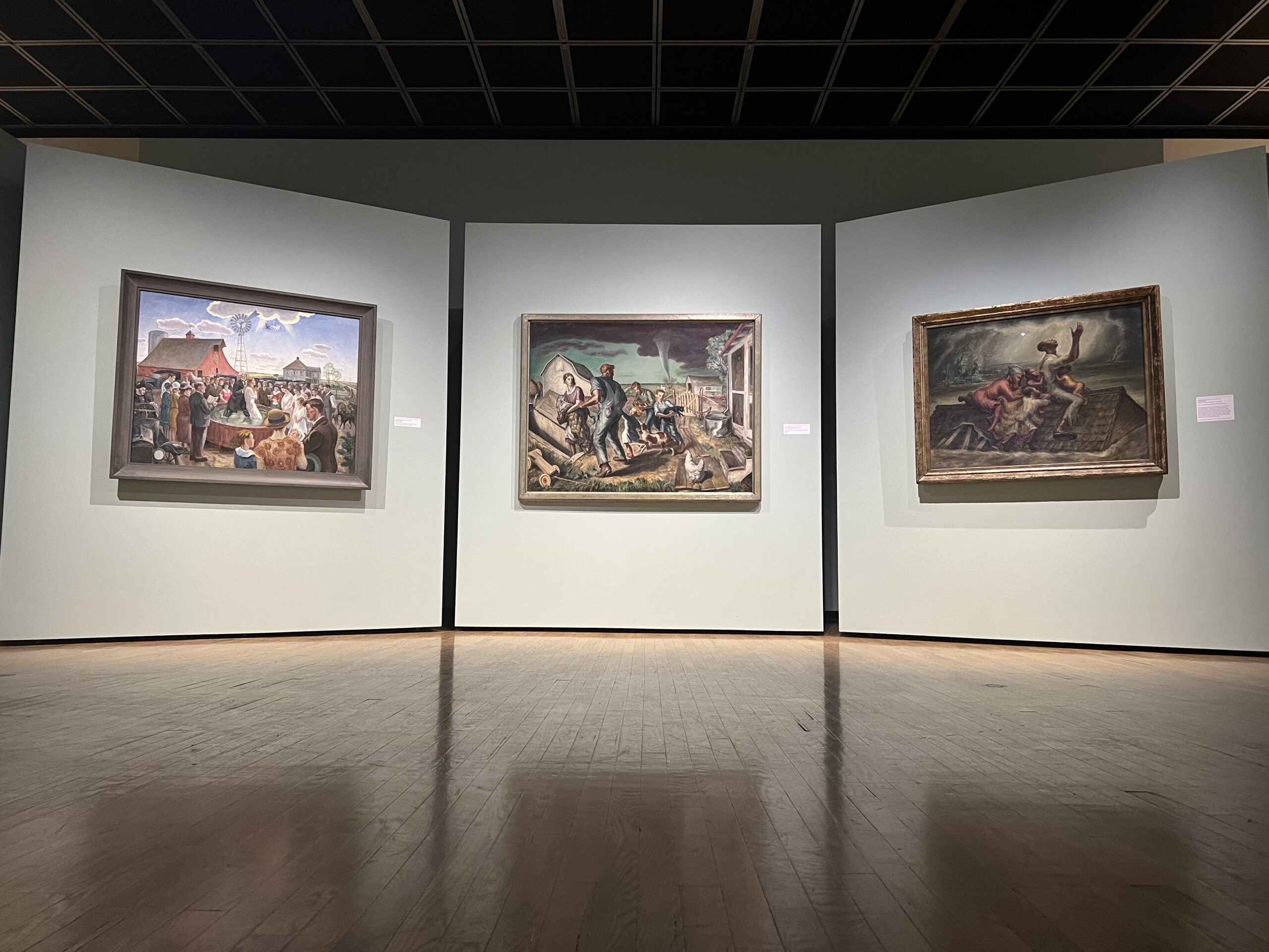 Gallery shot of John Steuart Curry's most iconic works, "Baptism In Kansas," loaned by The Whitney Museum of American Art, "The Tornado (Tornado Over Kansas)," from the Muskegon Museum of Art, and "The Mississippi" loaned by the Saint Louis Art Museum.