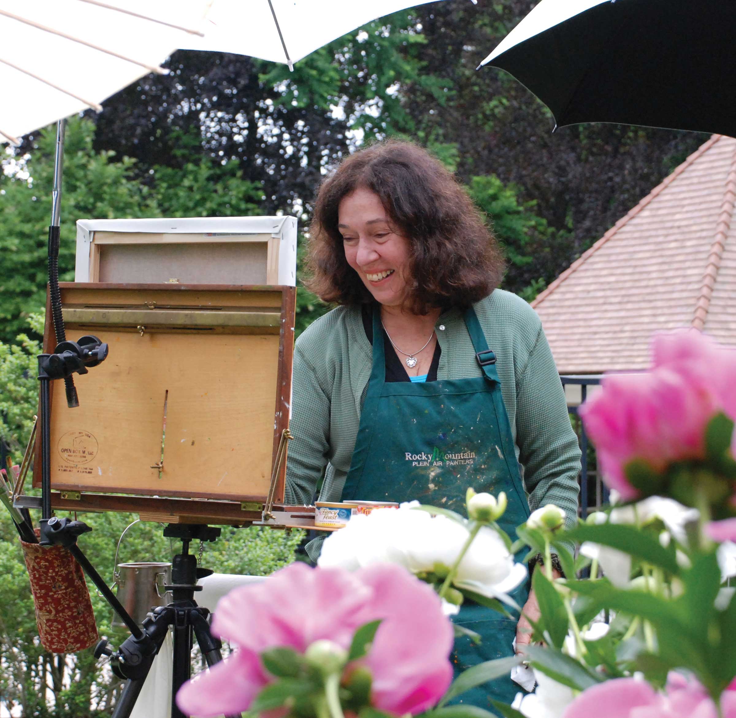 Kathy Anderson painting peonies in a garden